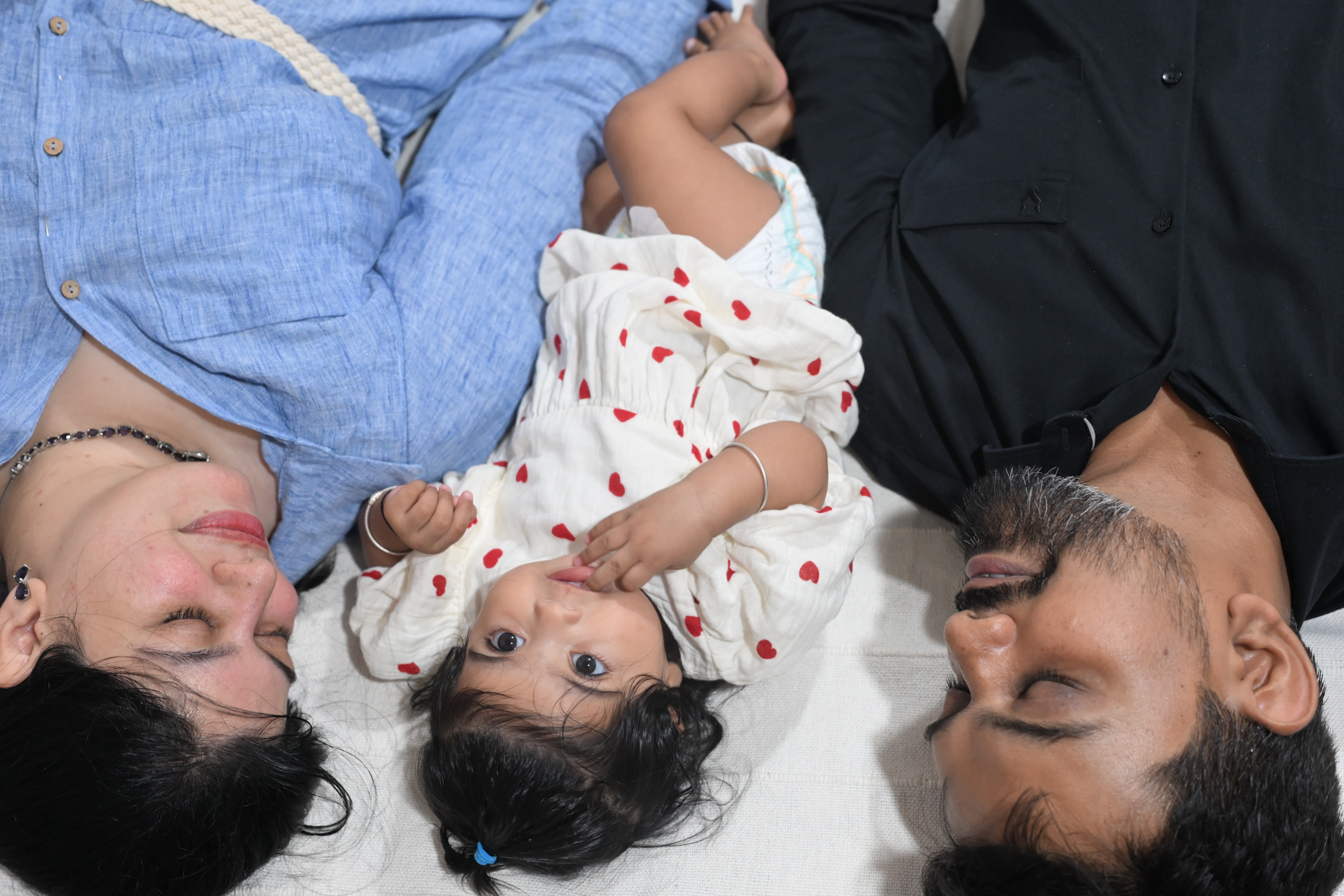 Exhausted parents asleep while baby is still wide awake